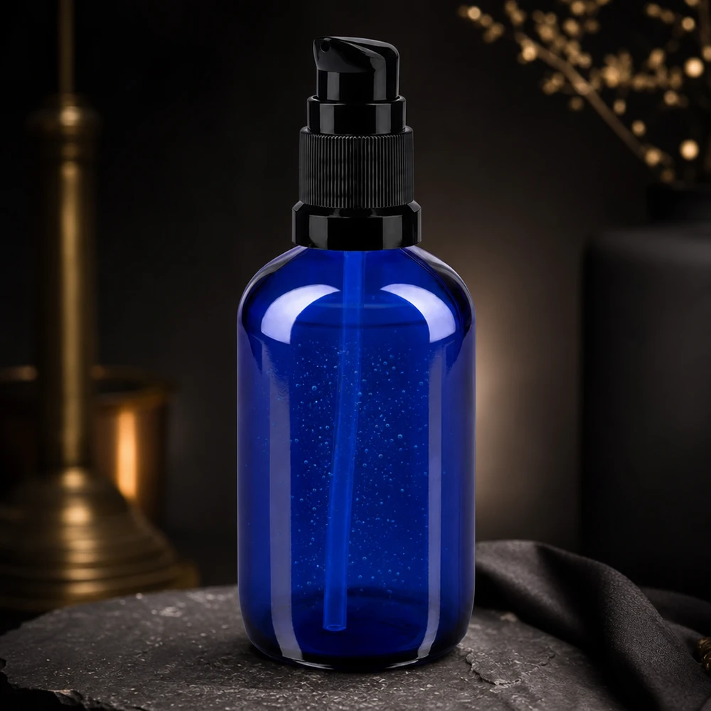 Apothekenflasche blau 100ml PumpVerschluss schwarz Standard 100ml Kosmetikflasche Blau mit schwarzem Pumpspender auf Naturstein vor goldenem Kerzenhalter