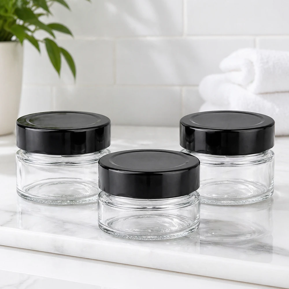 Drei 80ml Rundgläser mit schwarzen BasicSeal Deckeln UNiTWIST auf weißer Marmorplatte Badezimmer Ambiente leer