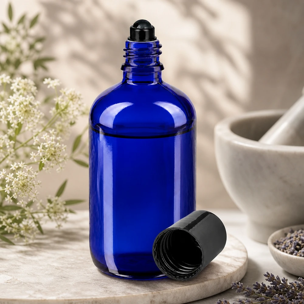 Blaue 100ml Glasflasche mit Rollkugel für Aromatherapie neben Mörser und Kräutern