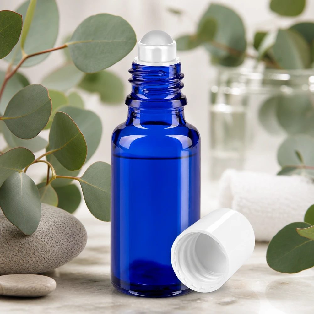 Apothekenflasche blau 20ml Roll-On Verschluss weiß Roll-On Flasche 20ml kobaltblau mit weißem Deckel umgeben von Eukalyptus und Spa-Elementen