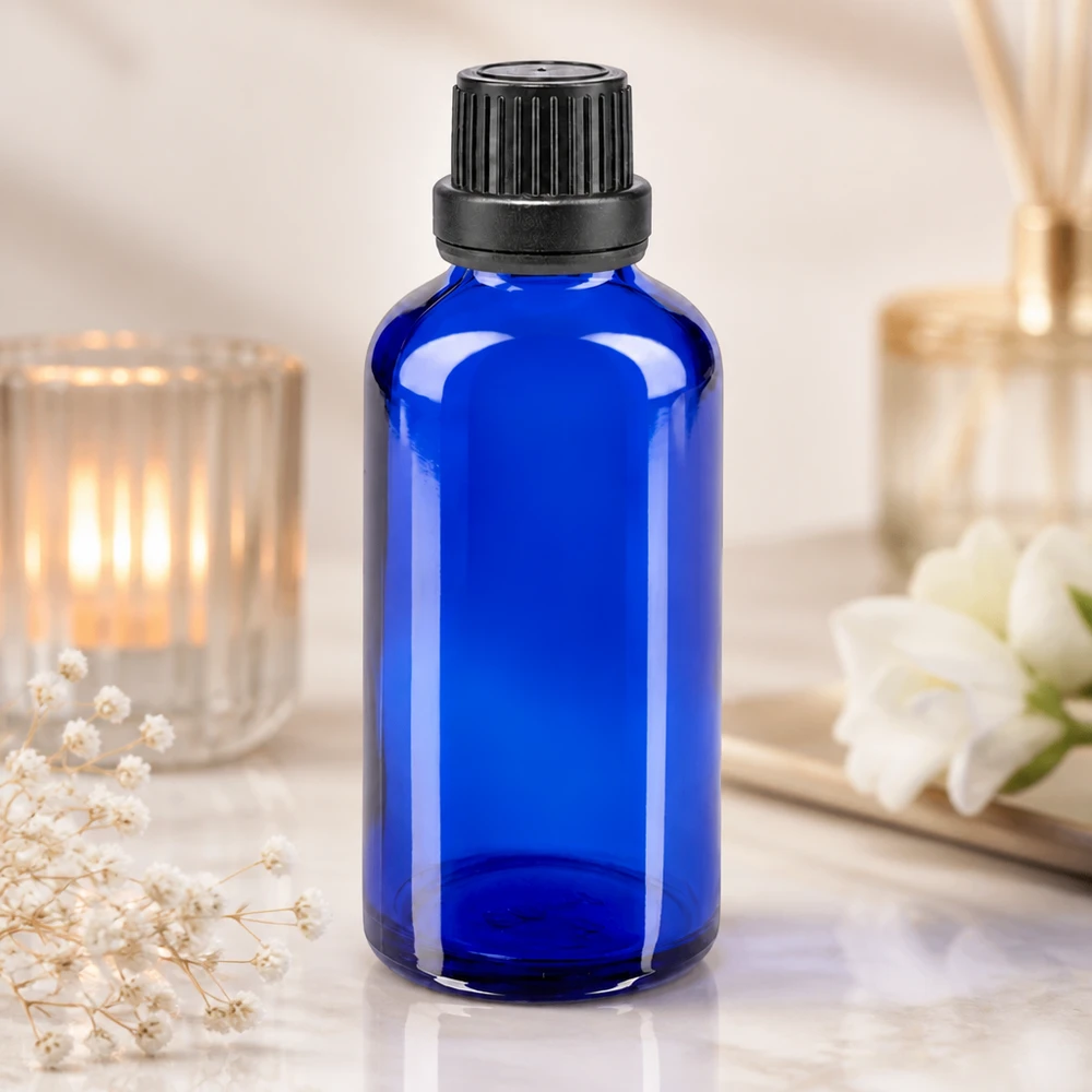 Apothekenflasche blau 50ml Tropfverschluss Giessring 2mm schwarz Originalitätsverschluss Zylindrische blaue 50ml Tropfflasche aus Apothekenglas mit schwarzem OV-Deckel vor Raumduftdiffuser
