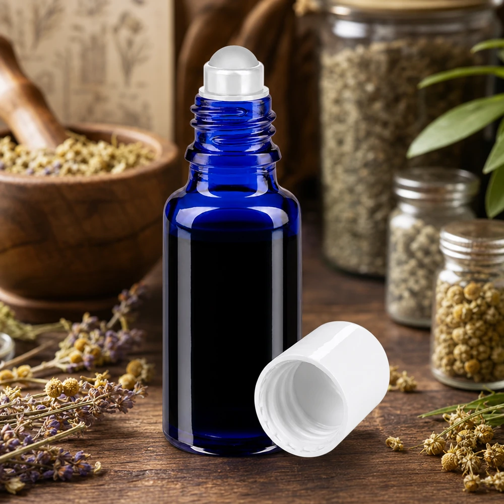 Aromatherapie Roll-On Flasche 20ml in Blau mit weißem Deckel neben Kamillenblüten und Lavendel