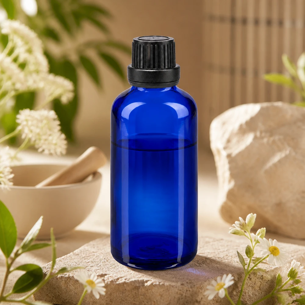 Apothekenflasche blau 50ml Tropfverschluss Giessring 2mm schwarz Originalitätsverschluss Pharmazeutische 50ml Blaугlasflasche mit Präzisionstropfer und schwarzem OV auf rustikalem Steinpodest