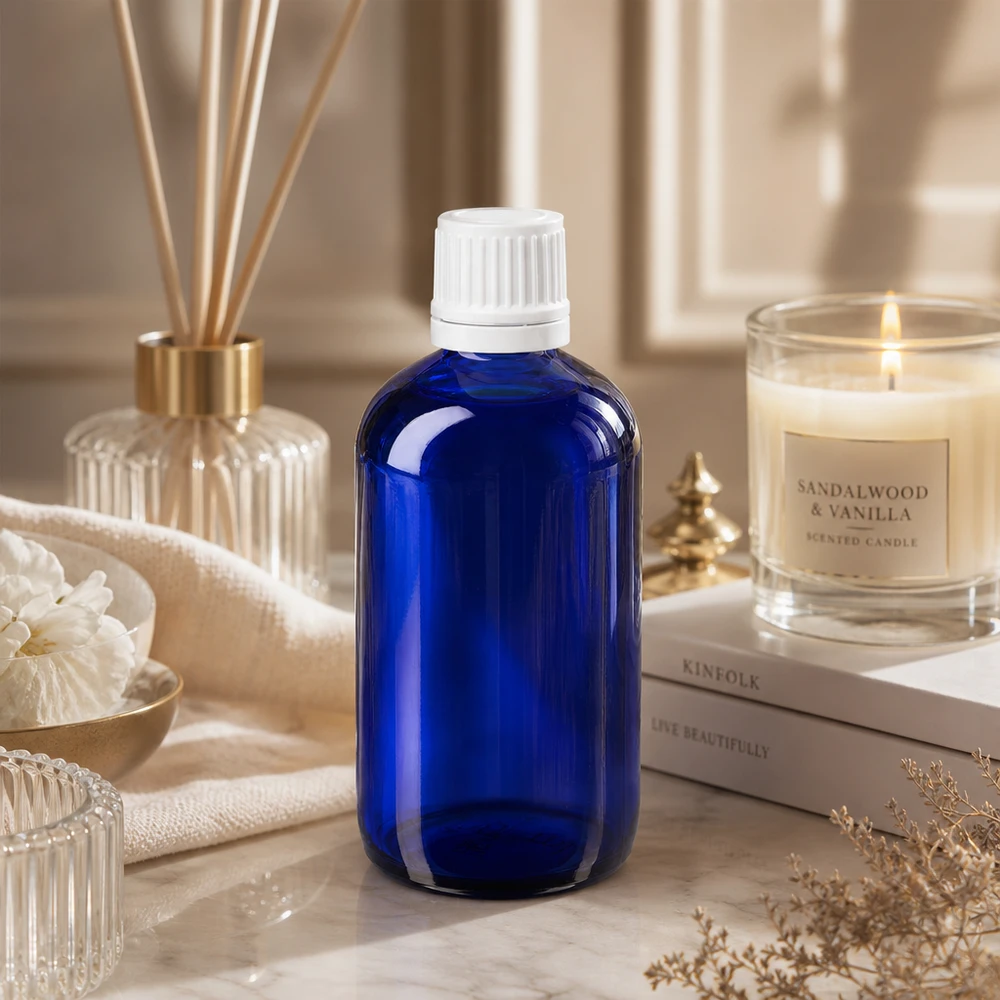 Apothekenflasche blau 100ml Schraubverschluss weiß Originalitätsverschluss Kleine blaue Glasflasche 100ml mit weißem Sicherheitsdeckel zwischen Kerze und Bambusstäbchen