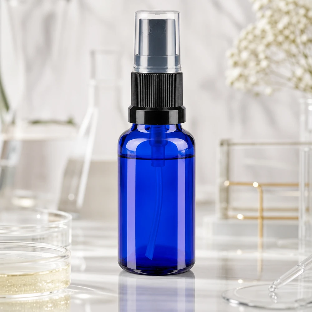 Apothekenflasche blau 20ml Sprayaufsatz schwarz 20ml blaues Apothekerglasfläschchen mit schwarzem Sprühaufsatz vor Laborhintergrund