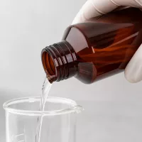 Abfüllprozess mit brauner lichtgeschützter 100ml PET Flasche und Laborglasgefäß