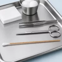Unsteriles Einmalwattestäbchen mit Naturholzstiel auf klinischem Behandlungstablett