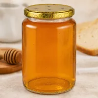 Großes 1000g Honigglas mit Prägung am Boden neben Honigstab und Brot auf Holzbrett Küchenszene Imkereibedarf