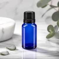 Schlanke blaue 10ml Glasflasche mit geripptem schwarzen Deckel und Eukalyptus Deko