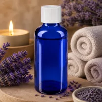 Kobaltblaue Apothekerflasche mit KiSi-Verschluss umgeben von Lavendel gerollten Handtüchern