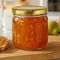500g Honigglas mit Bienenwaben-Deckel gefüllt mit goldener Marmelade neben Brot und grünem Apfel auf Holzbrett
