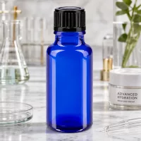 Blaue Tropfflasche 20ml aus Borosilikatglas mit schwarzem Standardverschluss auf Marmor