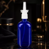 Zylindrische blaue Glasflasche 100ml mit weißem Nasensprayaufsatz und schmaler Applikatordüse