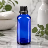 Rundschulterflasche 50ml Blauglas mit 11mm Schraubverschluss schwarz vor Marmorhintergrund