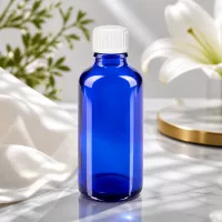 Hochwertige blaue Glasflasche 50ml mit UV-Schutz und weißem Schraubdeckel in Studioaufnahme