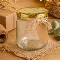 500g Honigglas mit Bienenwaben-Deckel und Geschenkanhänger auf Bastelmatte mit Naturdeko