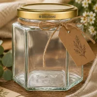 Leeres 520g BioSeal Honigglas hexagonal mit Golddeckel und rustikaler Kraftpapier-Banderole als Geschenkverpackung