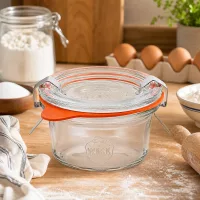 WECK 50ml Sturzglas RR60 auf Holzarbeitsplatte in Backambiente mit Mehl Eiern und Backzutaten als Küchenszenerie