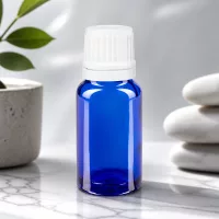 Kleine blaue Dosierflasche aus Apothekerglas mit geripptem weißem Sicherheitsverschluss