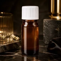 Kompakte 5ml Braunglasflasche mit weißem KiSi-Deckel neben goldenen Dekorationsgegenständen