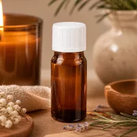 5ml ätherisches Öl Flasche Braunglas mit weißem KiSi-Tropfverschluss zwischen getrockneten Blüten