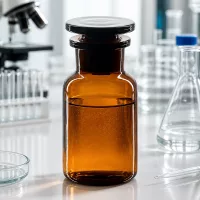 Bernsteinglas Weithalsflasche 100ml Rundschulter mit schwarzem Stopfen auf weißer Laborfläche