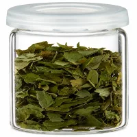 Durchsichtiges Vorratsglas mit getrockneten grünen Blättern ideal zur Gewürzaufbewahrung