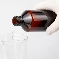 Braune Kunststoffflasche 1000ml mit weißem OV beim sicheren Ausgießen in Glasbecher