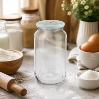 Leeres 1062ml Rundglas mit mintgrünem Herz-Deckel auf Küchenarbeitsplatte zwischen Backzutaten und Küchenutensilien