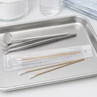 Wattestäbchen steril 2 Stück mit weißem Applikationskopf auf chirurgischem Edelstahltablett