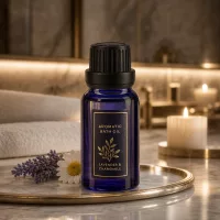 Kompakte blaue Tropfflasche aus Apothekenglas neben Lavendel und Kamilleblüten auf Marmor