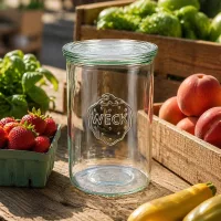 WECK Sturzglas 1000ml RR100 leer im Freien auf Holztisch umgeben von frischem Obst und Gemüse in Holzkisten