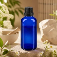 Pharmazeutische 50ml Blaугlasflasche mit Präzisionstropfer und schwarzem OV auf rustikalem Steinpodest