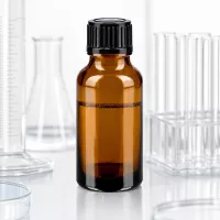 Apothekerflasche 20ml Braunglas lichtgeschützt schwarzer Verschluss auf weißer Oberfläche