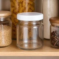 UNiTWIST 53ml Glas mit weißem Deckel neben Pasta Reis und Pfefferkörnern im organisierten Vorratsregal