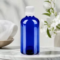 Stilvolle 100ml Glasflasche in Kobaltblau mit ergonomischem weißem Schraubverschluss für einfache Handhabung