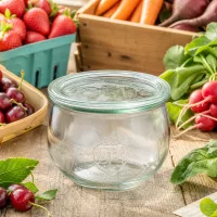 WECK Tulpenglas 580ml RR100 mit Glasdeckel zwischen frischem Obst und Gemüse auf rustikalem Holztisch arrangiert