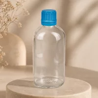 Minimalistische 100ml ClearLine Flasche UT18 mit blauem OV Verschluss im Lifestyle-Setting