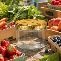 300g Honigglas leer mit Bienenwaben-Deckel zwischen frischem Obst und Gemüse auf Marktstand als Vorratsglas