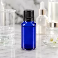 Dunkelblaue 20ml Flasche aus Apothekerglas mit 8mm Ausgießer zwischen Serumflaschen